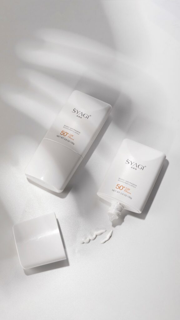 Two SPF 50 sunscreen bottles on a white surface with shadows, minimalist design.