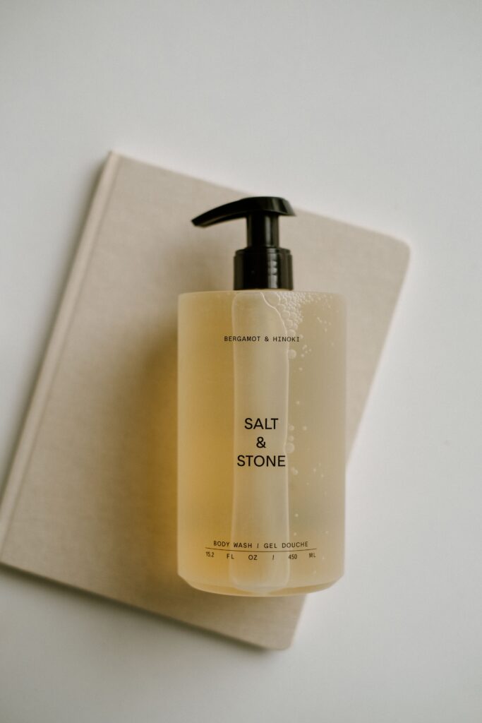 A stylish still life shot of Salt & Stone body wash bottle on a beige background.