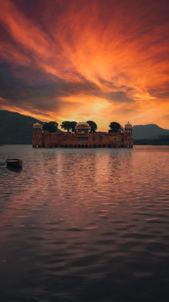 Explore the enchanting Jal Mahal set against a vivid sunset sky, capturing the romance of Rajasthan.